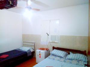 a bedroom with a bed and a small refrigerator at Tubarao Branco Suites Central Area in Itacaré