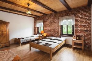 a bedroom with two beds and a brick wall at Agrohippika in Kondratów