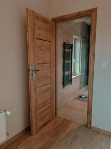 eine Holztür in einem Zimmer mit Spiegel in der Unterkunft Agroturystyka ''Na Polanie'' in Sól