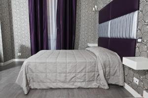 a bedroom with a bed and a purple wall at Hotel Nardizzi Americana in Rome