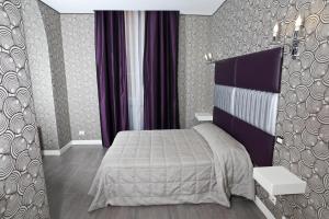 a bedroom with a bed and purple curtains at Hotel Nardizzi Americana in Rome