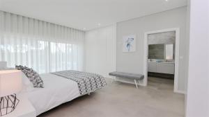 a white bedroom with a bed and a window at Villa Waterfall - Clever Details, luxury, 5min walking from the center in Vilamoura +82 photos