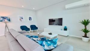 a living room with a couch and a tv at Villa Waterfall - Clever Details, luxury, 5min walking from the center in Vilamoura