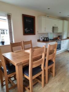 a wooden dining room table and chairs in a kitchen at Fir Tree Cottage in Blairgowrie