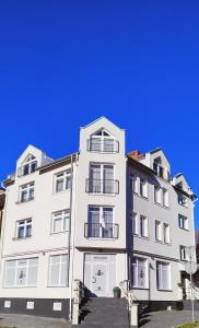 a tall white building with a blue sky in the background at Apartament MT Badger Centrum in Ustrzyki Dolne