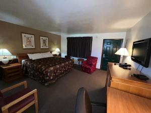a hotel room with two beds and a television at Spinning Wheel Motel in Baraboo