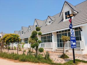 uma casa com uma placa de rua em frente em The Cottage at Chiyaphum em Chaiyaphum