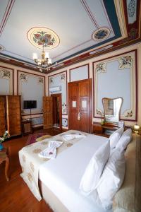 a bedroom with a large white bed and a chandelier at Sarnıç Butik Otel in Istanbul