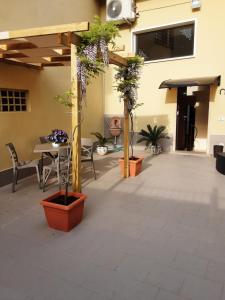 a patio with potted plants and a table and chairs at Dimora normanna in Aversa
