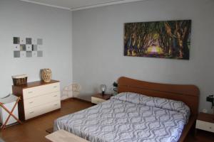 1 dormitorio con 1 cama y una pintura en la pared en Ninna House, en Villa San Sebastiano