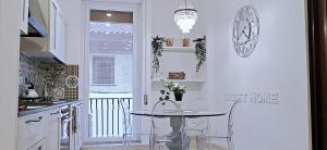 cocina blanca con mesa y ventana en CASA PAOLINA NEL CENTRO DI BRACCIANO, en Bracciano