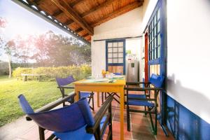 un porche con sillas y una mesa en una casa en Finca La Colina De Los Azulejos, en Guadalupe