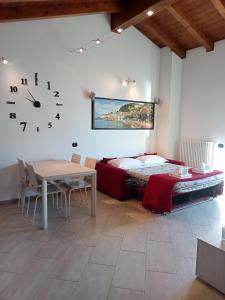 Casa Olive 2 في Oliveto Lario: غرفة بسرير وطاولة وساعة