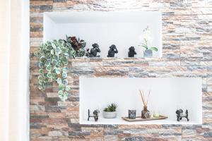 a brick wall with two white shelves with plants at Casa da BellaVista in Ponte de Lima