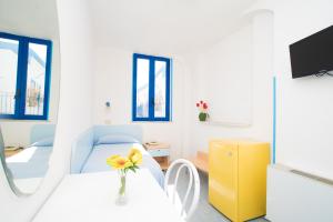 a room with a bed and a table with a vase of flowers at Hotel Celeste in Procida