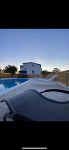 a picture of a swimming pool with a house in the background at Holiday home “MARKO” with heated pool! in Nin