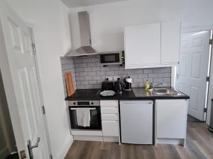 a small kitchen with a sink and a stove at Granada Apartments Derby Road in Blackpool