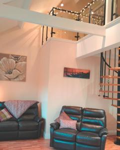 een woonkamer met een bank en een loft bij Beautiful cozy 3 bedroom 2 bathroom apartment in Newcastle upon Tyne