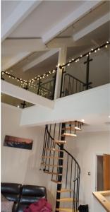 - un escalier en colimaçon dans un salon éclairé dans l'établissement Beautiful cozy 3 bedroom 2 bathroom apartment, à Newcastle upon Tyne