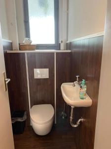 baño con aseo y lavabo y ventana en soulfactory budget, en Neu-Ulm