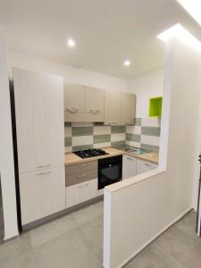 uma cozinha com armários brancos e um forno com placa de fogão em Interno 7 em Barletta