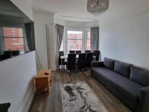 a living room with a couch and a table with chairs at Granada Apartments Derby Road in Blackpool