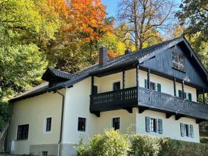 une maison avec un balcon au-dessus dans l'établissement Chalet an der Donau direkt bei Regensburg, 5 Sterne DTV, à Pentling