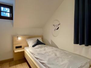 a small bedroom with a white bed and a window at Chalet an der Donau direkt bei Regensburg, 5 Sterne DTV in Pentling