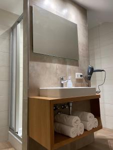 a bathroom with a sink and a mirror and towels at Chalet an der Donau direkt bei Regensburg, 5 Sterne DTV in Pentling +26 photos