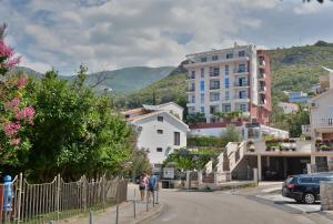 twee mensen die over een straat lopen in een stad bij Villa Katarina in Budva