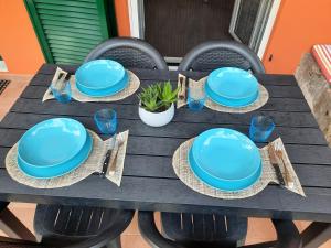 a wooden table with blue plates and napkins on it at Appartamento Blu in Deiva Marina +17 photos