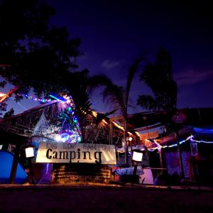 un cartel que dice acampar frente a un edificio con luces en Casa de los Santos Camping y eco cabañas en Holbox Island