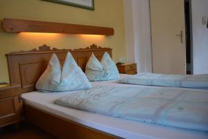 a bedroom with two beds with white sheets and pillows at Pension Foidl in Waidring