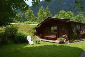 a small cabin with a bench in a yard at Pension Foidl in Waidring