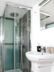 a bathroom with a glass shower and a sink at NOVECENTO in Monopoli +32 photos