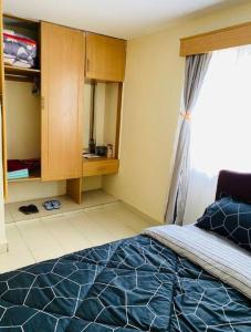 a bedroom with a blue bed and a window at Lovely apartment near town with WiFi and parking in Meru
