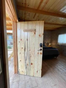 uma porta de madeira num quarto com uma cama em Cabaña San Tony em Valle de Guadalupe