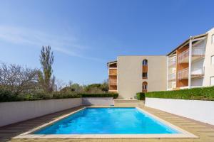 a swimming pool in front of a building at appartement 2p PRIMAVERA in Cap d'Agde