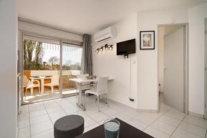 a living room with a table and a dining room at appartement 2p PRIMAVERA in Cap d'Agde