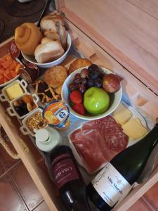 a tray filled with food and a bottle of wine at Villa Vinicolla Hospedagem Conceito in Bento Gonçalves