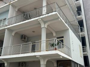 a white building with balconies on the side of it at Perdja Apartment II in Velipojë