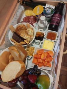 a tray filled with different types of food on a table at Villa Vinicolla Hospedagem Conceito in Bento Gonçalves