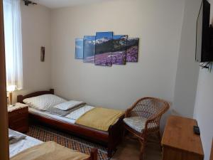 um quarto com uma cama e uma cadeira em Apartament Zakopane Kamieniec 10i em Zakopane