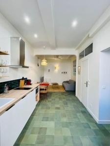 a large kitchen with a green tile floor and white cabinets at LA MOUNINE - Hyper centre - 37m2 - 4 pers in Cassis