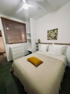 a bedroom with a large bed with a yellow pillow on it at LA MOUNINE - Hyper centre - 37m2 - 4 pers in Cassis