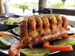 a plate of food with meat and vegetables on a table at Pousada Rancho do Nhesko in Garuva
