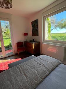 a bedroom with a bed and a large window at Blumereve in Blumeray