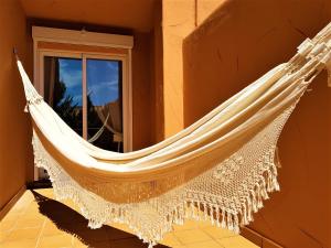 eine Hängematte, die an einer Wand neben einem Fenster hängt in der Unterkunft Ample Luxury Apart Fancy Marbella Golf & Padel in Marbella