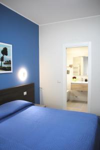 1 dormitorio azul con 1 cama y baño en B&B Delle Serre, en Messina