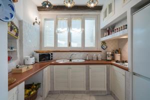 a kitchen with white cabinets and a counter top at CasaMia Positano - sea view and private outdoor hot tub in Positano +11 photos